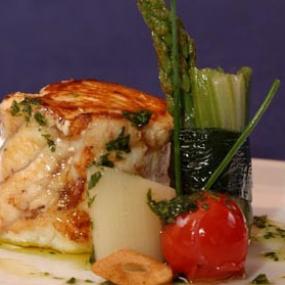 Pixin braseado con verduras tiernas, crujiente de ajo y aceite de perejil